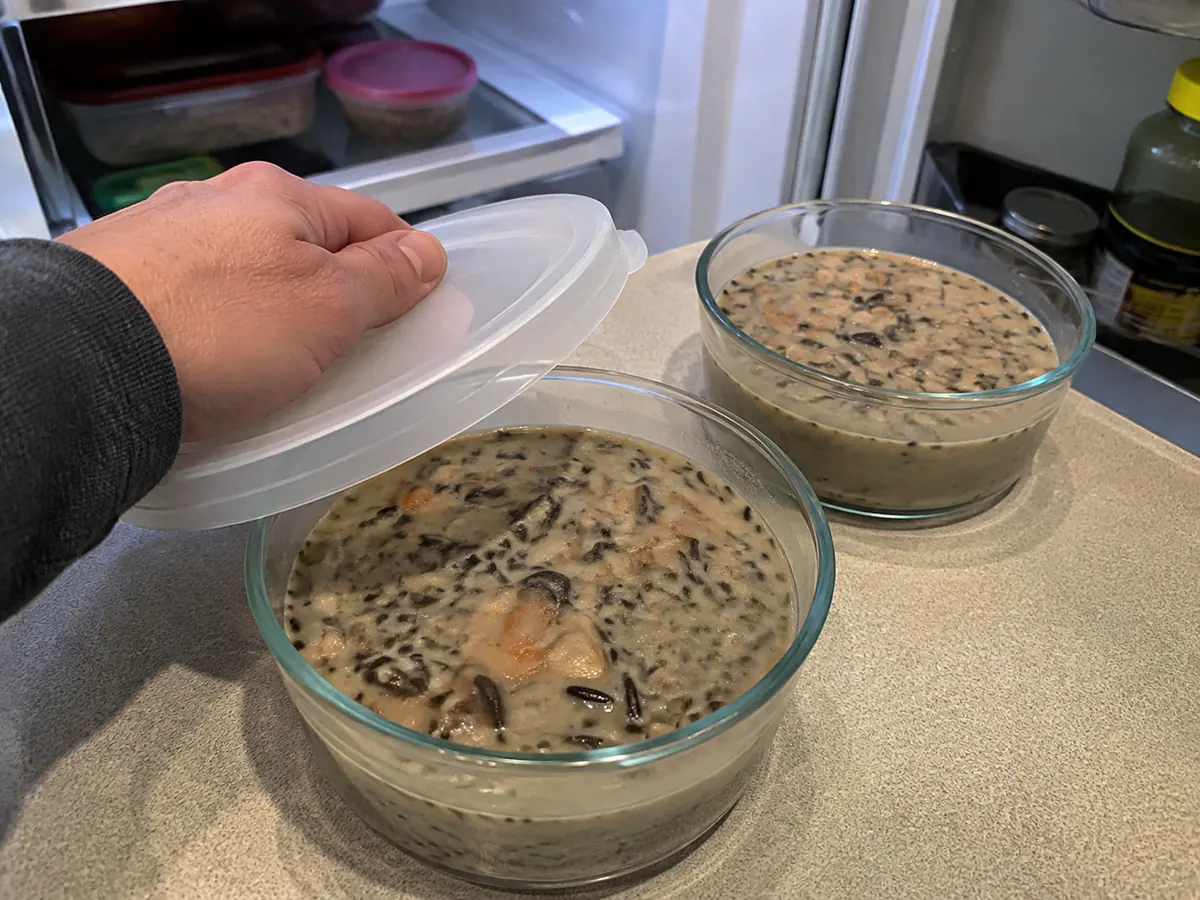Mushroom wild rice soup cooled in shallow covered containers for refrigerator storage.