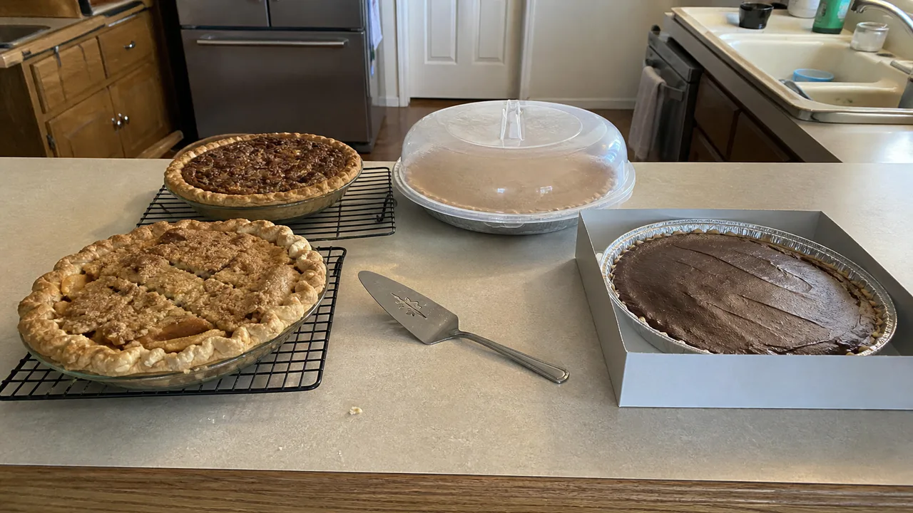 Pumpkin, pecan, apple, and chocolate cream pies arranged for make-ahead Thanksgiving dessert planning.