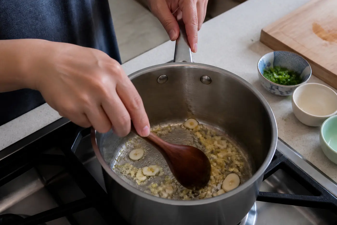 Ginger and garlic sautéing in a saucepan for tofu soup