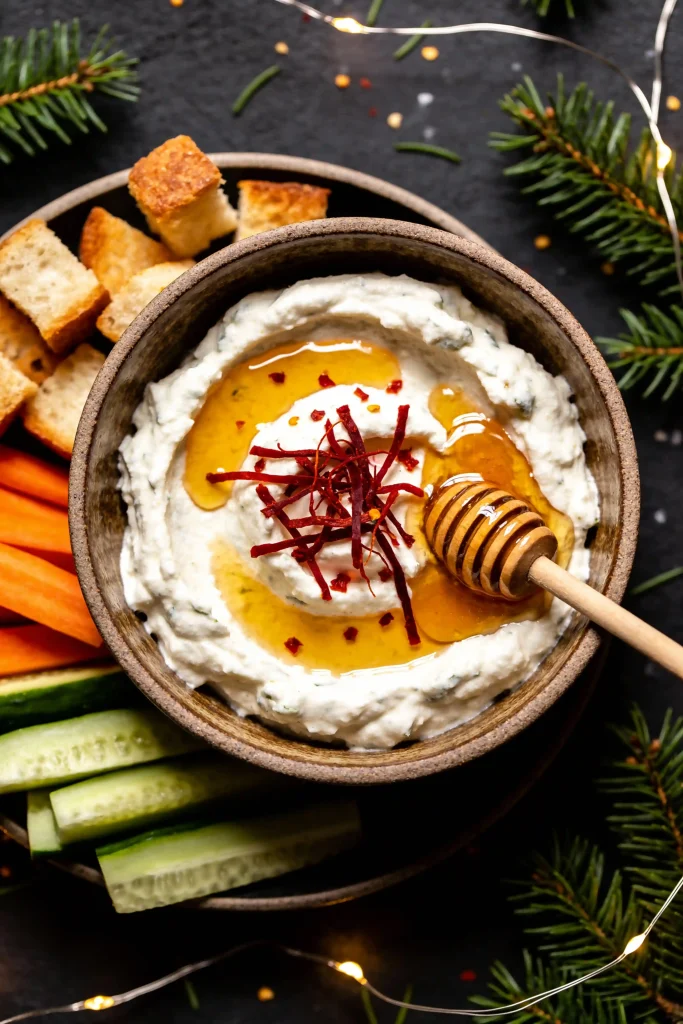 Whipped feta topped with honey and chili crisp and served with crackers for New Year's Eve.