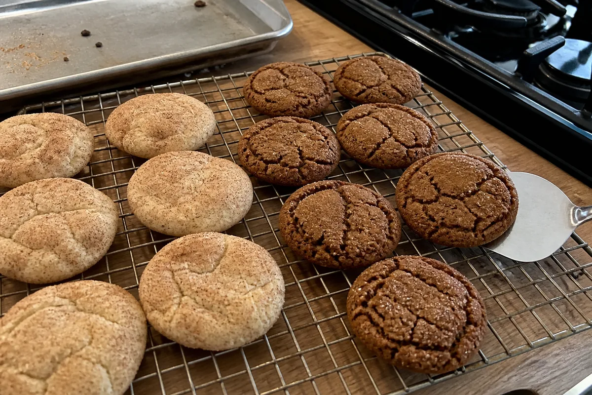 Chai snickerdoodles and crackled molasses ginger cookies on a home kitchen cooling rack.