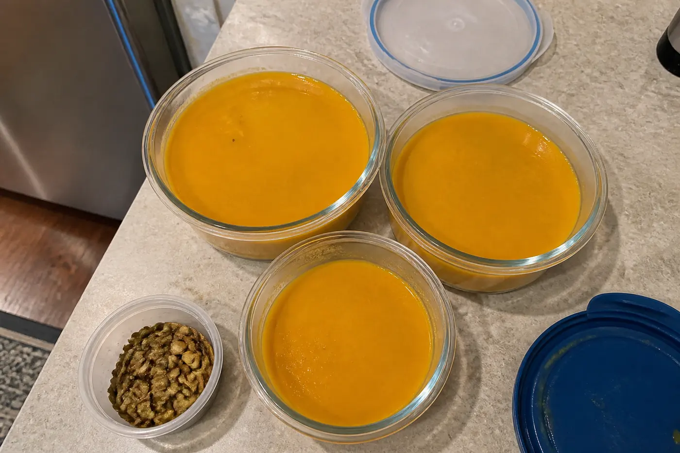 Butternut squash soup portioned into glass containers for refrigerator and freezer storage