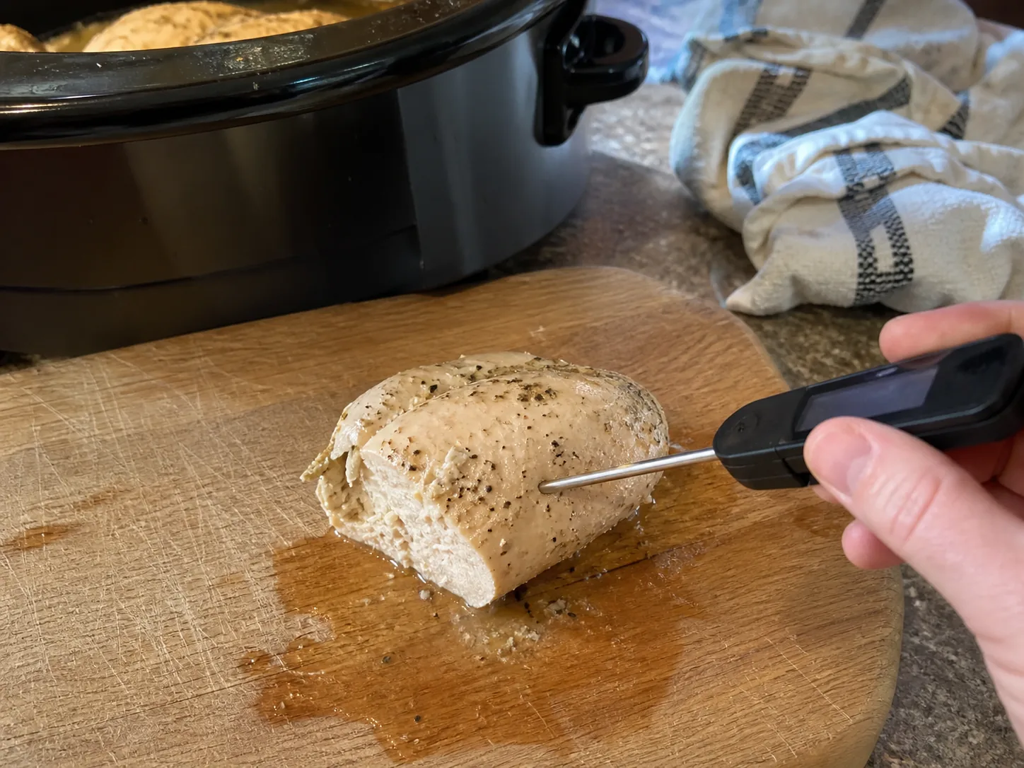 Checking crockpot chicken breast with an instant-read thermometer