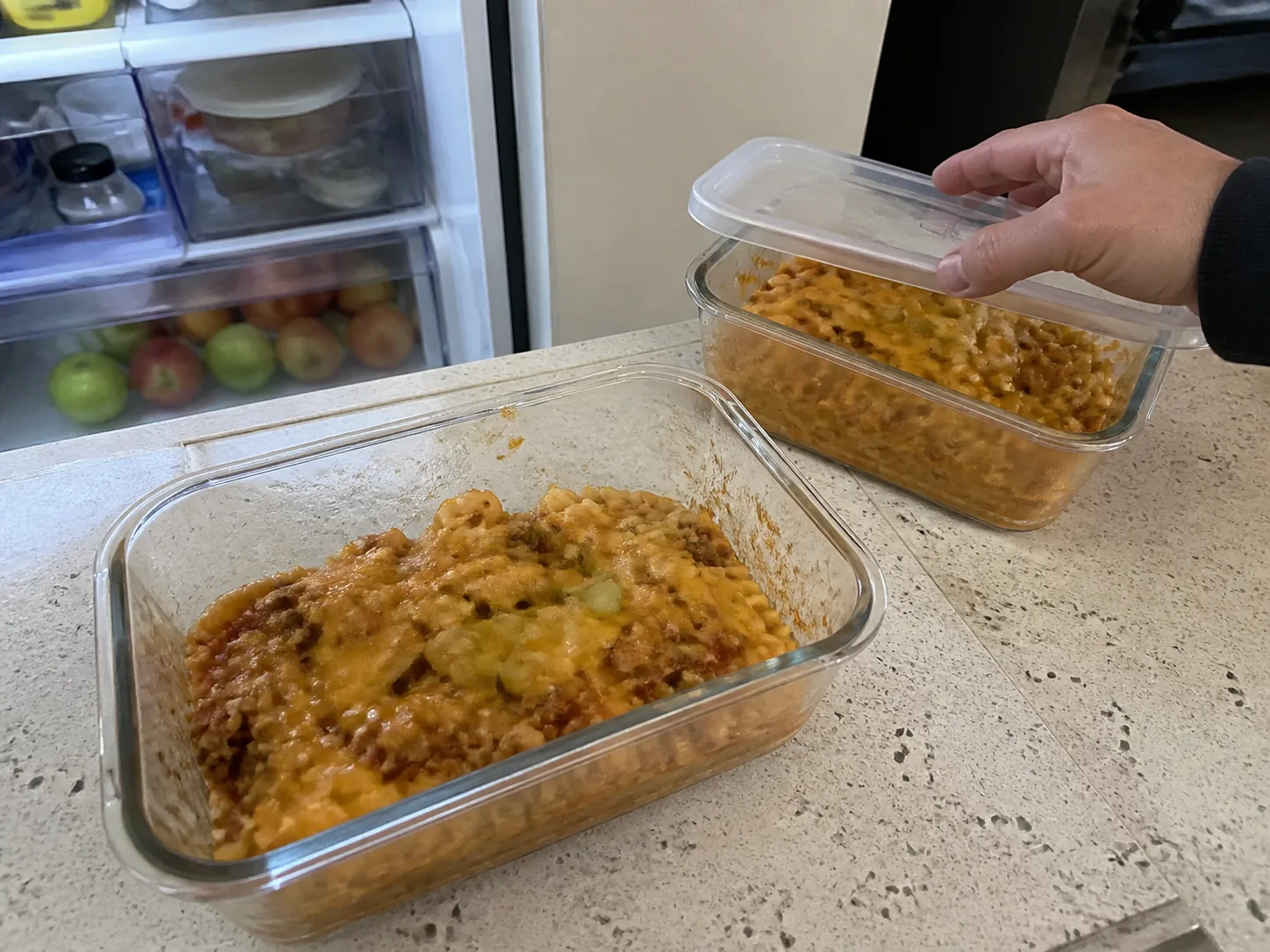 Leftover cheeseburger casserole portioned into glass containers for refrigeration.