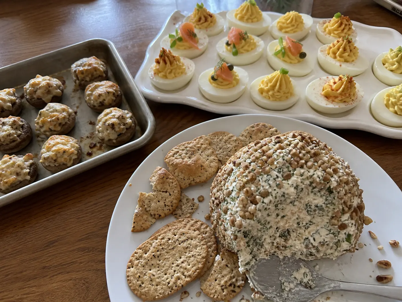 Christmas appetizer spread with smoked salmon cheese ball, deviled eggs, and cheesy stuffed mushrooms