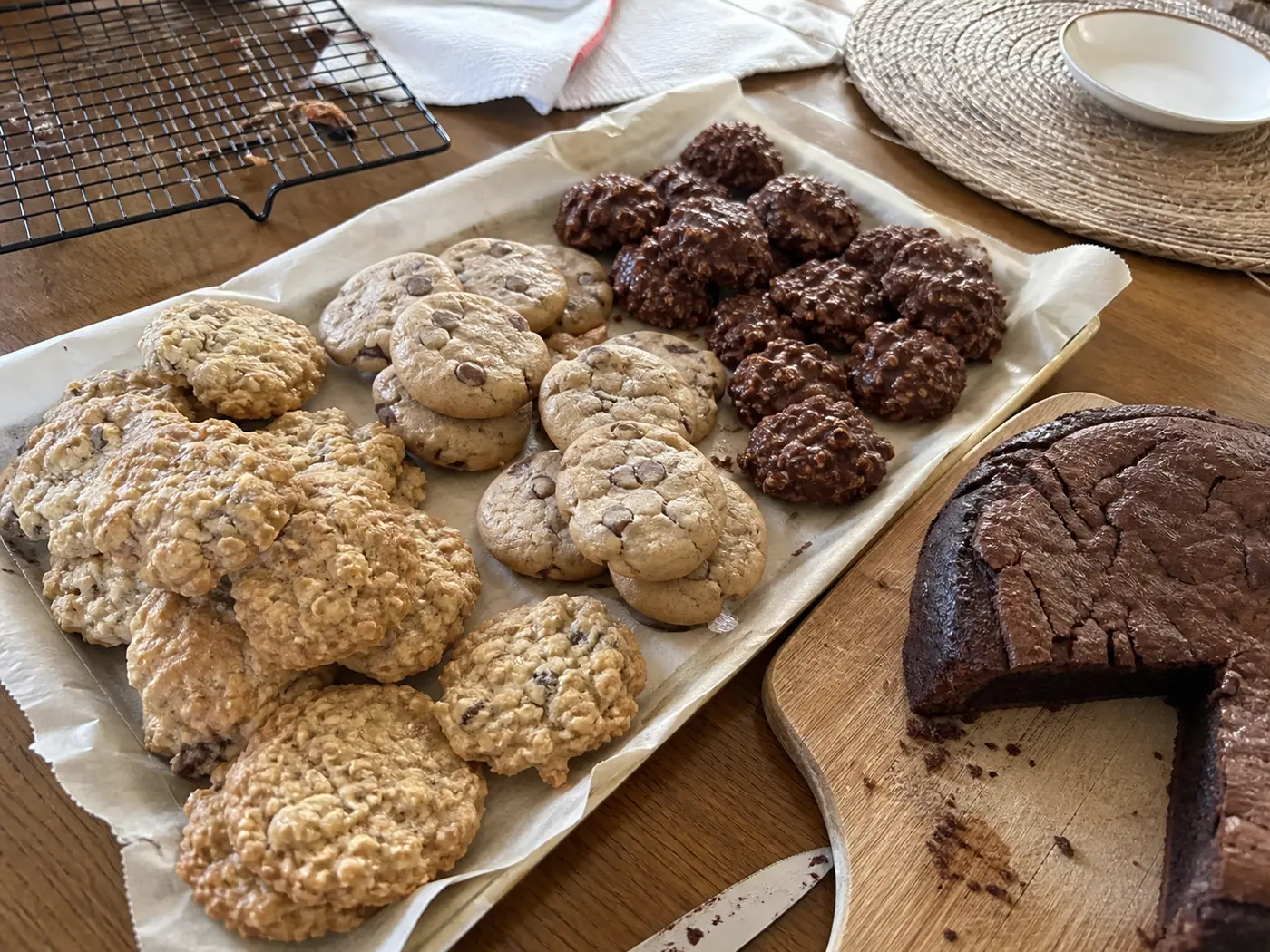 Christmas dessert spread with oatmeal cookies, chocolate chip cookies, no-bake cookies, and flourless chocolate cake