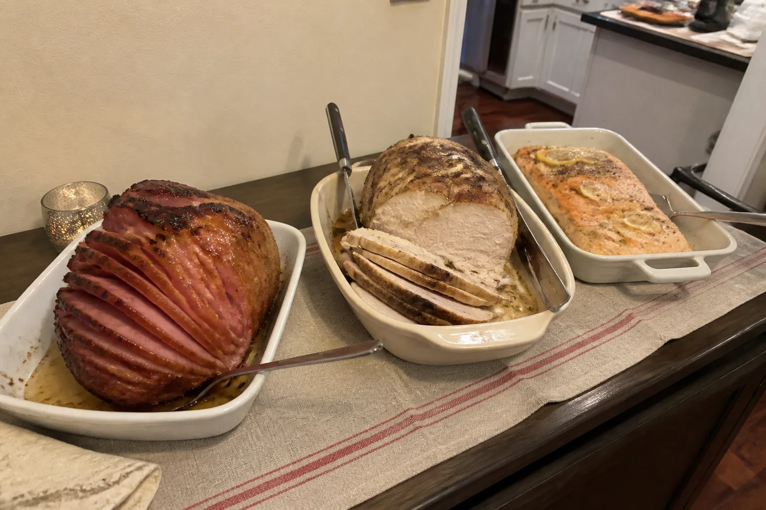 Christmas buffet with glazed ham, roasted turkey breast, baked salmon, and simple serving utensils.