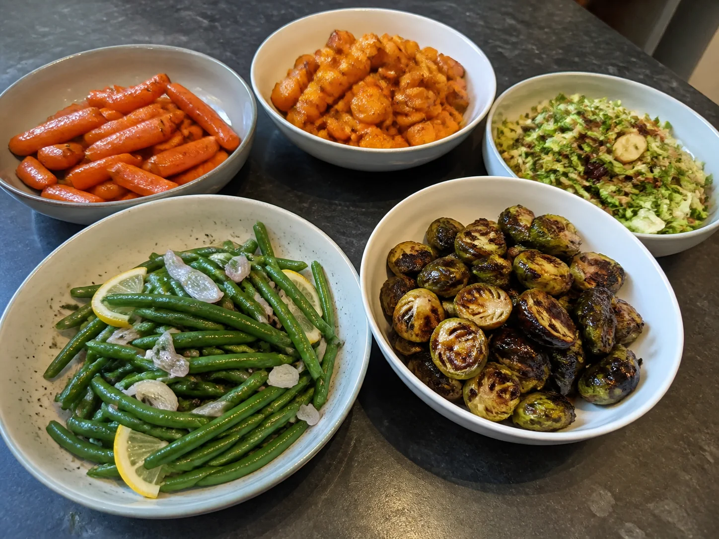 Christmas vegetable sides with lemon shallot green beans, honey carrots, Brussels sprouts, roasted squash, and a winter salad.
