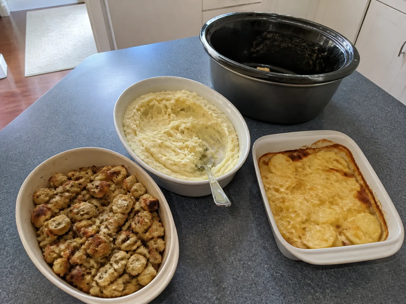 Slow-cooker herb stuffing, creamy mashed potatoes, and cheesy scalloped potatoes for Thanksgiving.