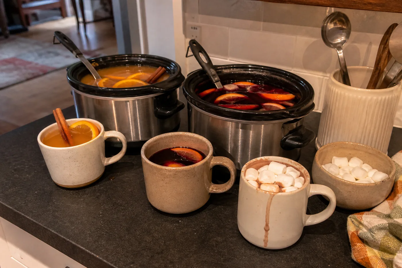 Slow-cooker apple cider, mulled wine, and hot chocolate served in mugs for Thanksgiving.