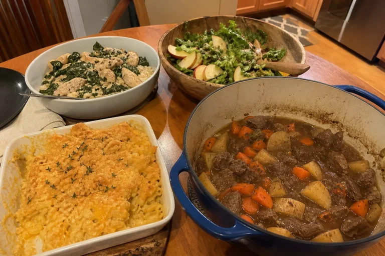Homemade fall dinner spread with beef stew, butternut squash macaroni and cheese, chicken with coconut kale and rice, and apple salad.