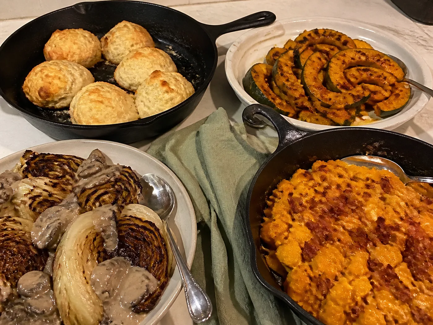 Keto dinner rolls, roasted acorn squash, cheesy butternut squash, and whole roasted cabbage for Thanksgiving