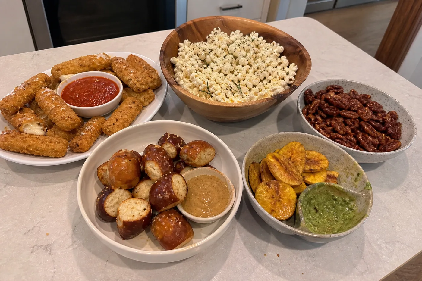 Mozzarella sticks, rosemary popcorn, spiced pecans, pretzel bites, and plantain chips with avocado dip