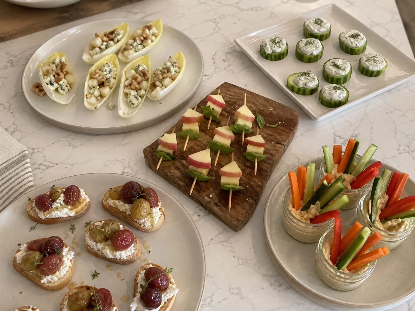 Pear endive cups, cucumber ranch bites, apple cheddar skewers, grape ricotta crostini, and vegetable hummus cups