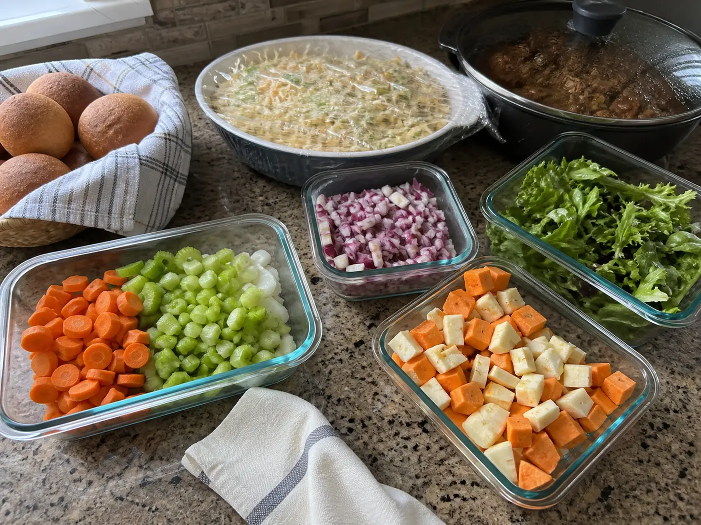 Labeled glass containers and covered baking dishes prepared ahead for a holiday dinner