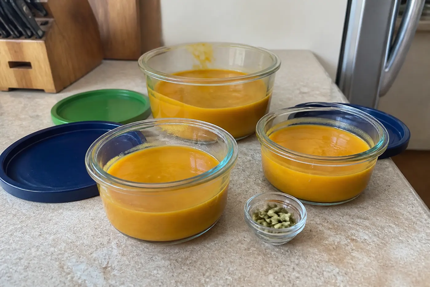 Pumpkin soup portioned into glass containers for refrigerator or freezer storage