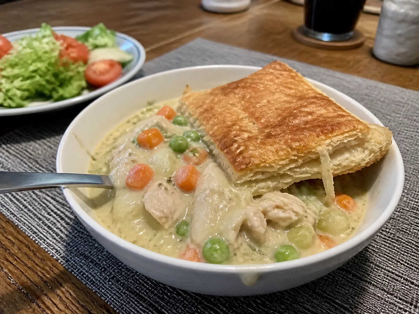Creamy slow cooker chicken pot pie soup with peas, carrots, chicken, and puff pastry.