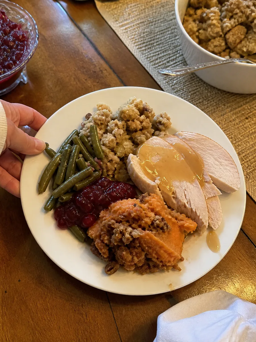 Sweet potato casserole served with turkey, stuffing, green beans, and cranberry sauce