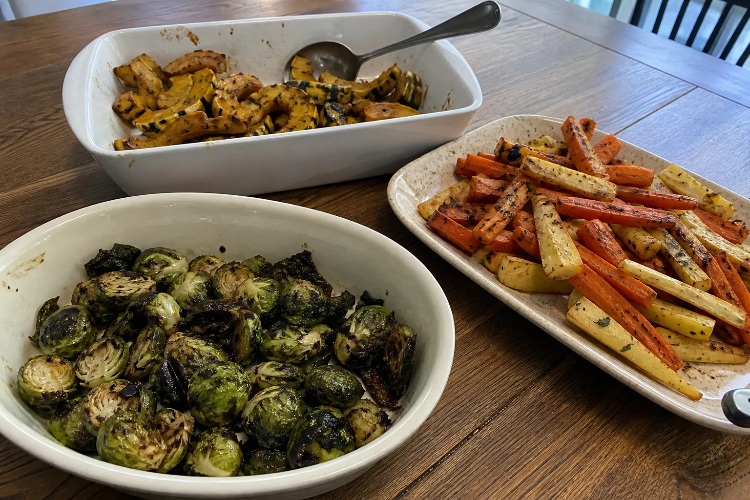 Three home-cooked Thanksgiving vegetable sides with Brussels sprouts, roasted carrots and parsnips, and winter squash.