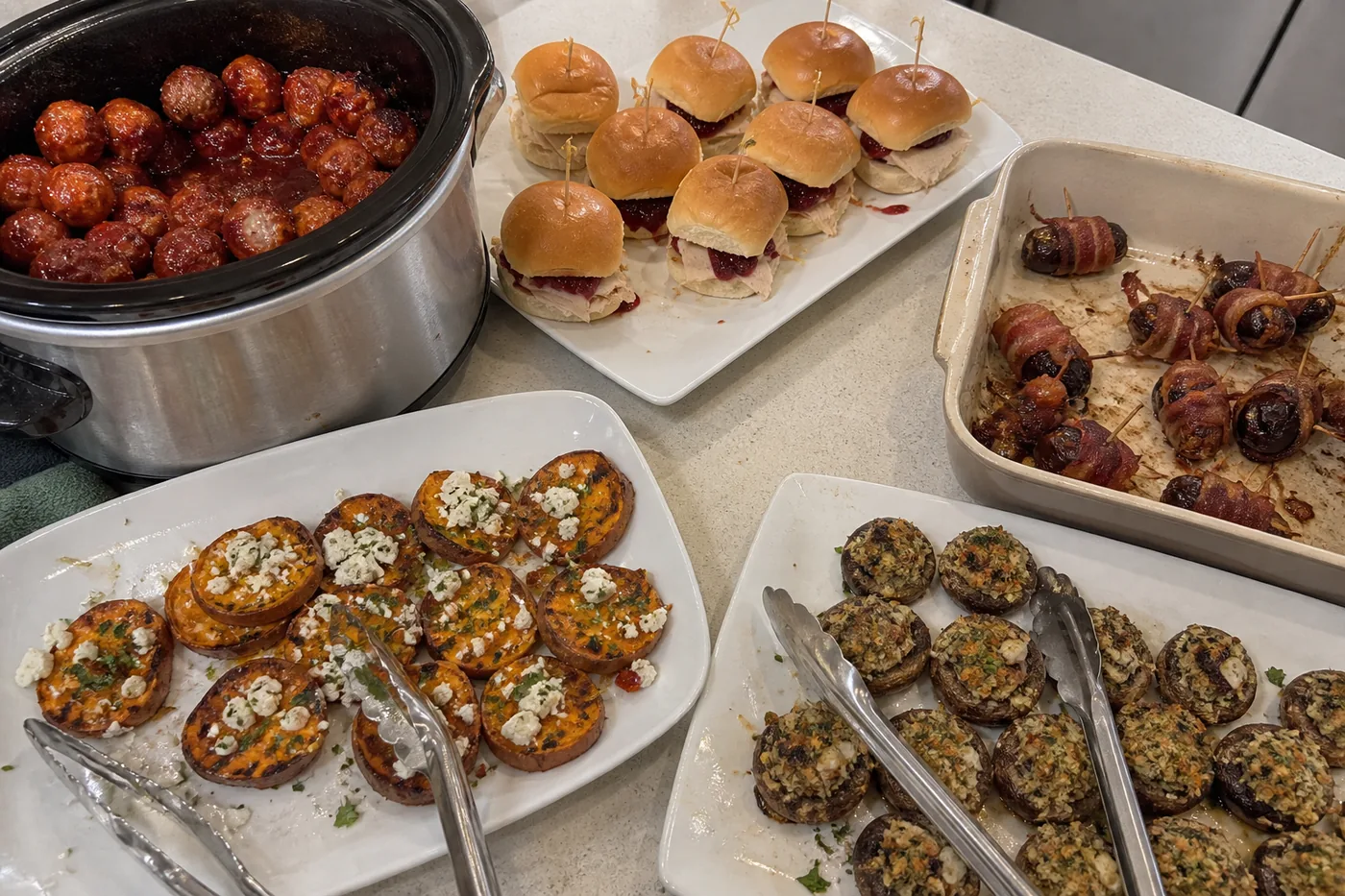 Cranberry glazed meatballs, turkey sliders, bacon-wrapped dates, sweet potato rounds, and stuffed mushrooms
