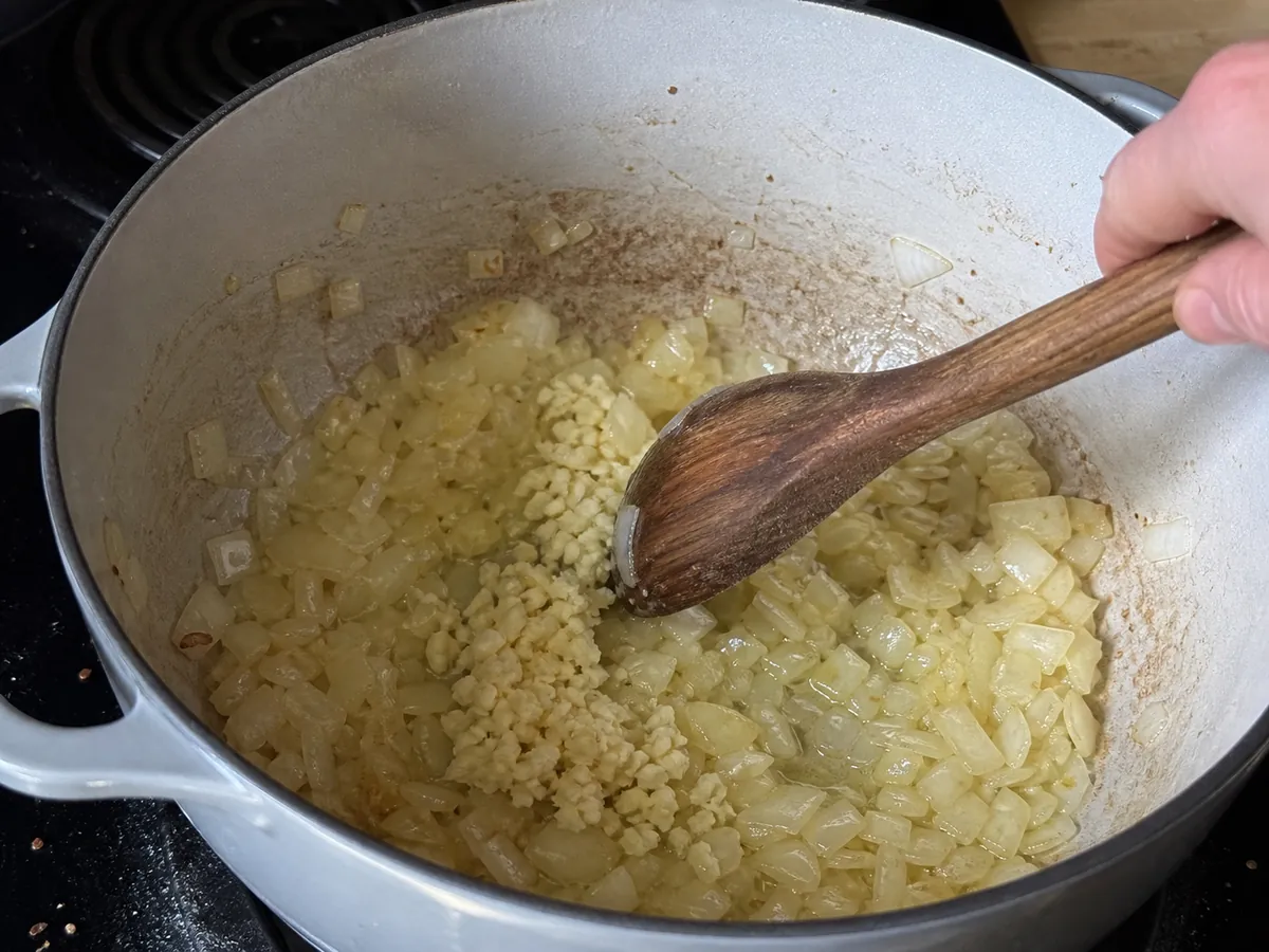 Diced onion and garlic sautéing in olive oil in a Dutch oven for white chicken chili