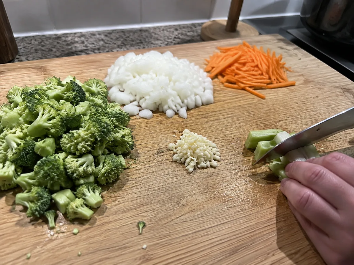 Broccoli florets, chopped onion, minced garlic, and julienned carrot prepared for soup.